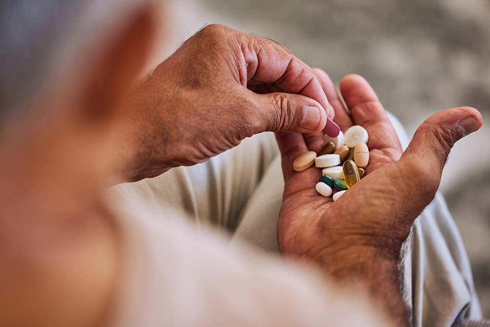 man's hand holding a pile of supplements