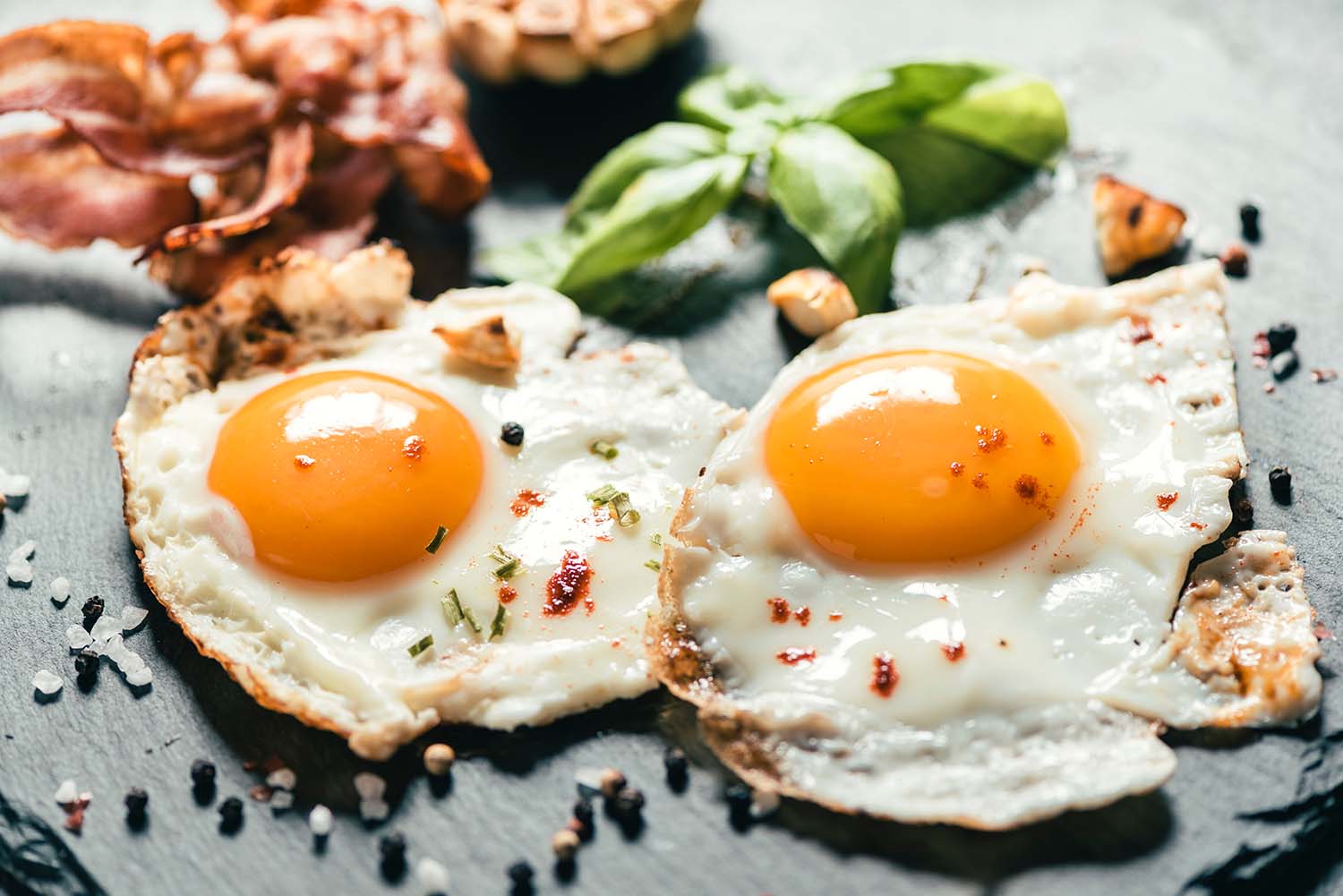 eggs-non-meat-protein sunny side up eggs sitting next to a sprig of herbs